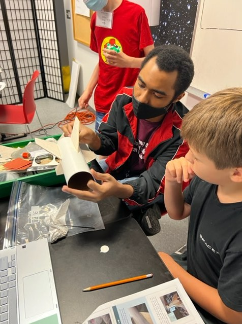 NASA intern shows young boy how to make a rocket out of materials