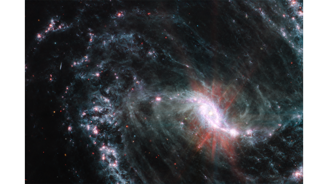A galaxy spiral with a bright, light pink eye-shaped center, just right of center with light blue web like spirals throughout.
