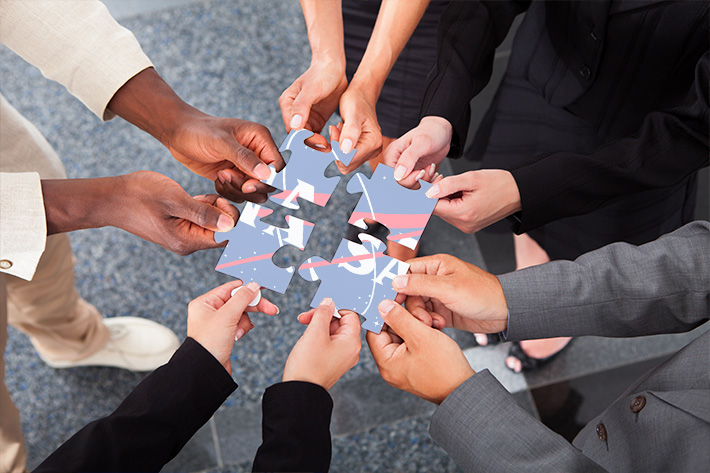 Hands of diversity holding puzzle pieces