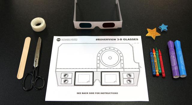 A picture of a printed paper with instructions on assembling glasses, and the finished paper glasses rest nearby it, along with some crayons and tape.