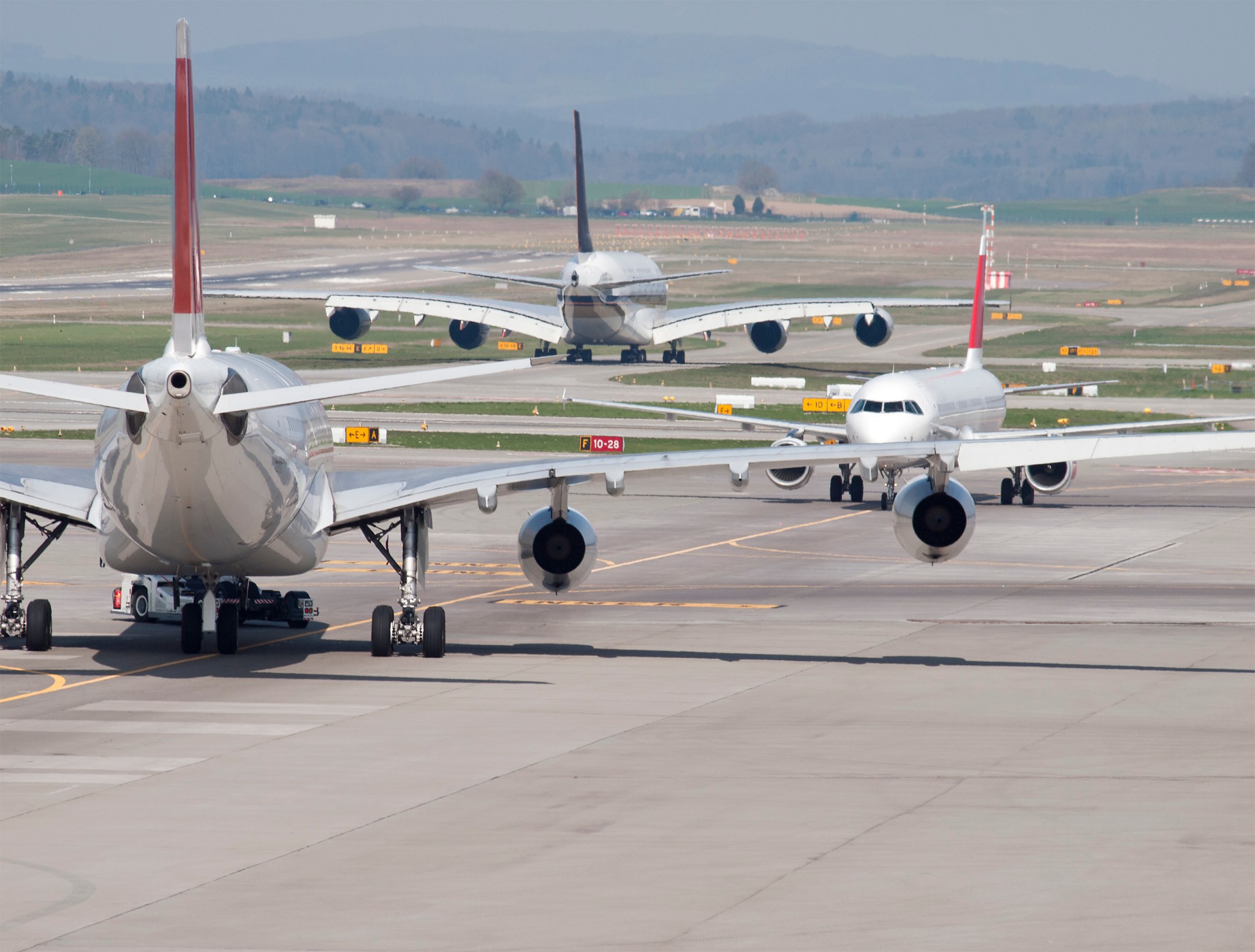 Commercial jets taxiing on and off the runway.