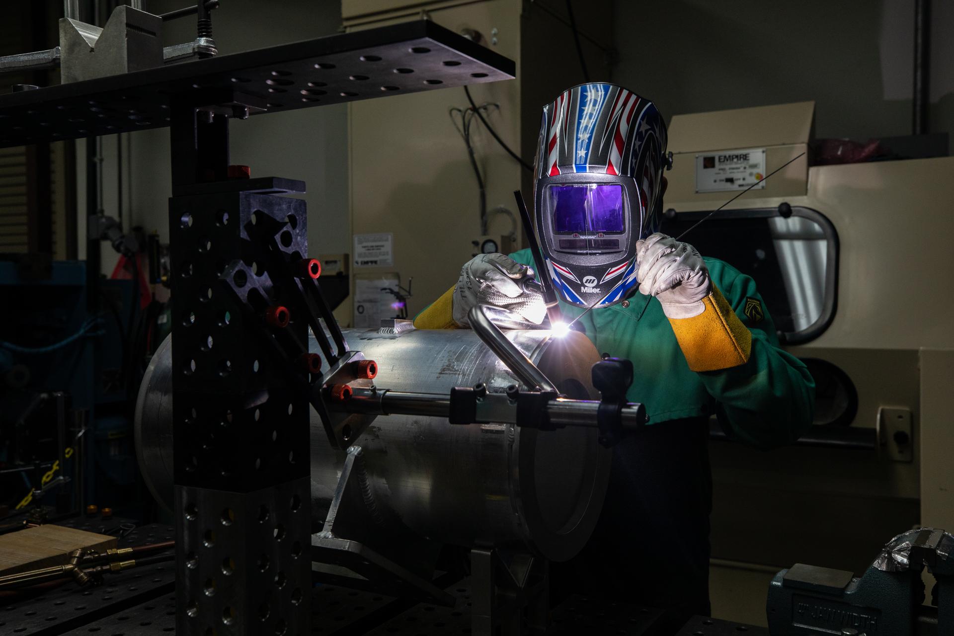 A mechanical engineering technician welds a part of a camera enclosure which will be used at Launch Complex 39B inside the Prototype Development Laboratory