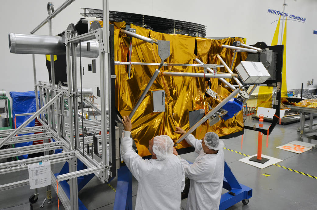 Test technicians work on a mock-up of the James Webb Space Telescope spacecraft bus