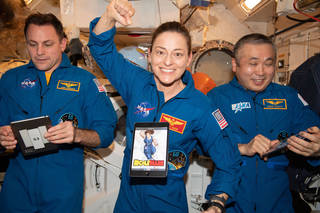 Imagen de tres astronautas durante una conferencia de prensa a bordo de la Estación Espacial Internacional.