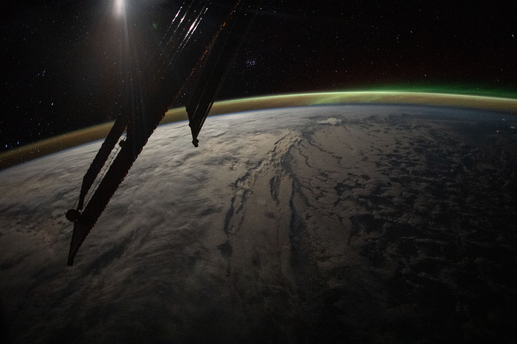 This image from the International Space Station shows a cloud-covered Earth at night.