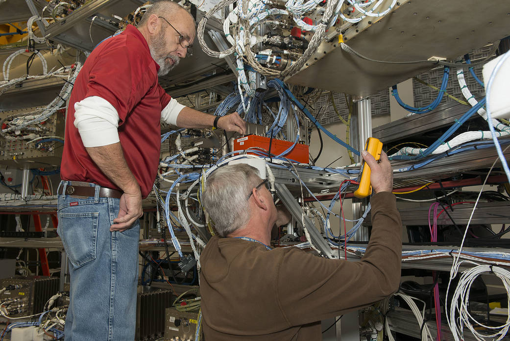 From left, Wayne Arrington and Steve Presti install Developmental Flight Instrumentation Data Acquisition Units.