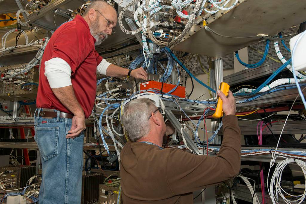 From left, Wayne Arrington and Steve Presti install Developmental Flight Instrumentation Data Acquisition Units.