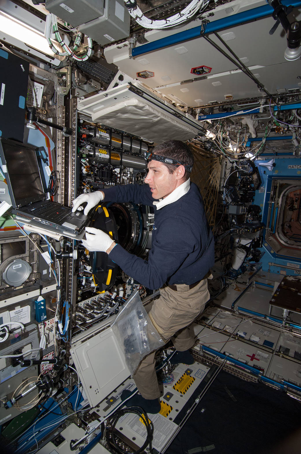 NASA astronaut Mike Hopkins, Expedition 38 flight engineer, performs in-flight maintenance on combustion research hardware in th