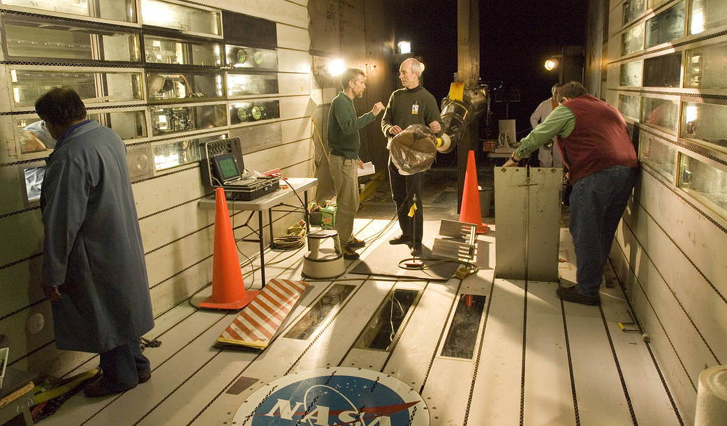 Scale model of Crew Exploration Vehicle (CEV), covered in plastic sheeting, is being prepared for testing.