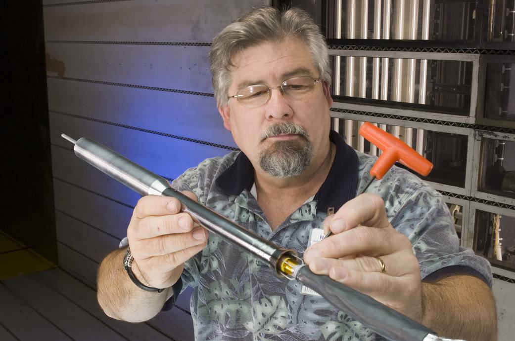 Test engineer Steve Buchholz adjusts the Crew Launch Vehicle (CLV) model.