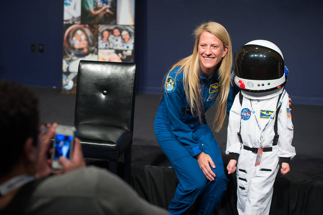 Astronaut Karen Nyberg poses for a photograph with an enthusiastic NASA Social attendee following a presentation about her time 