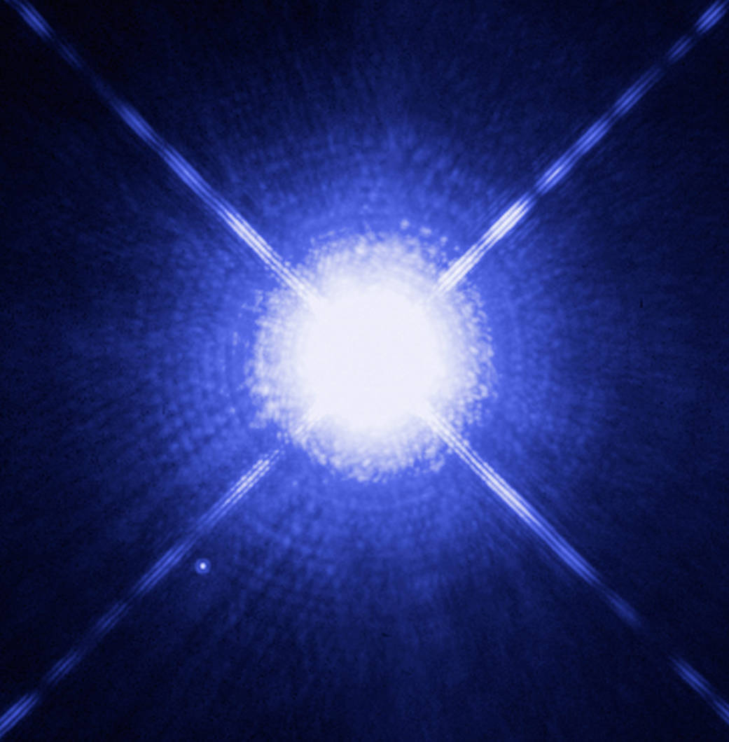 Brilliant closeup burst of white light radiating outward against deep space