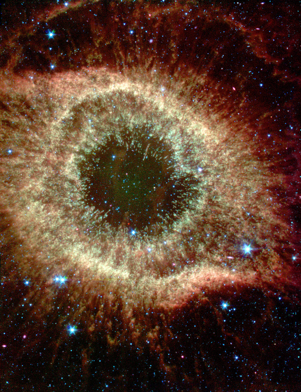 Eye shaped Helix Nebula in gold tones against darkness of space