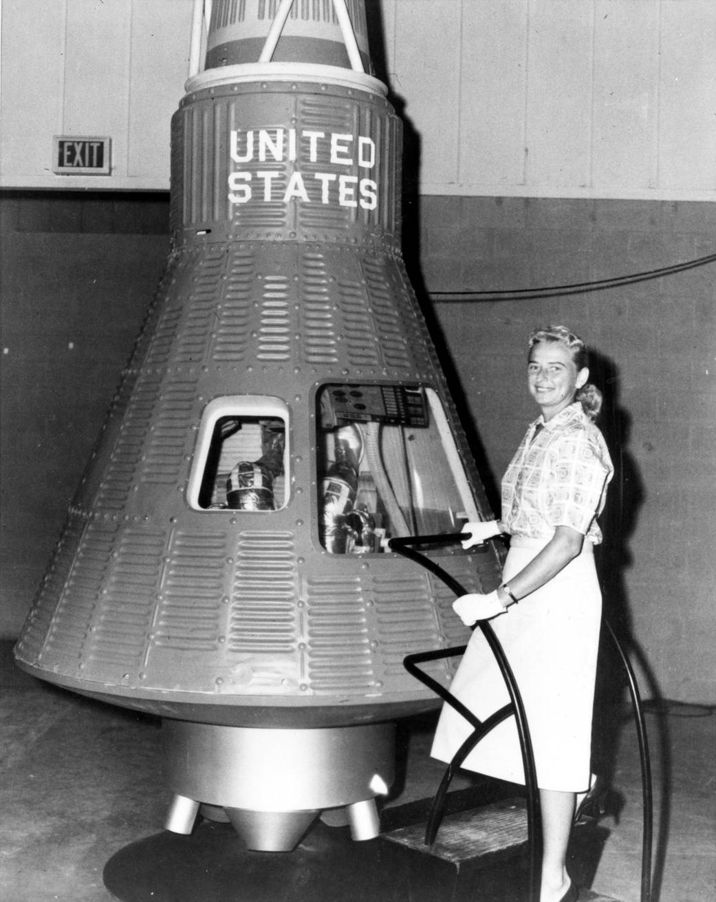 Jerrie Cobb poses next to a Mercury spaceship capsule.