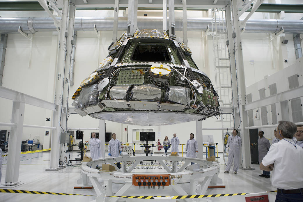 At the Operations and Checkout Building at NASA's Kennedy Space Center, the Orion crew module and heat shield are being moved in