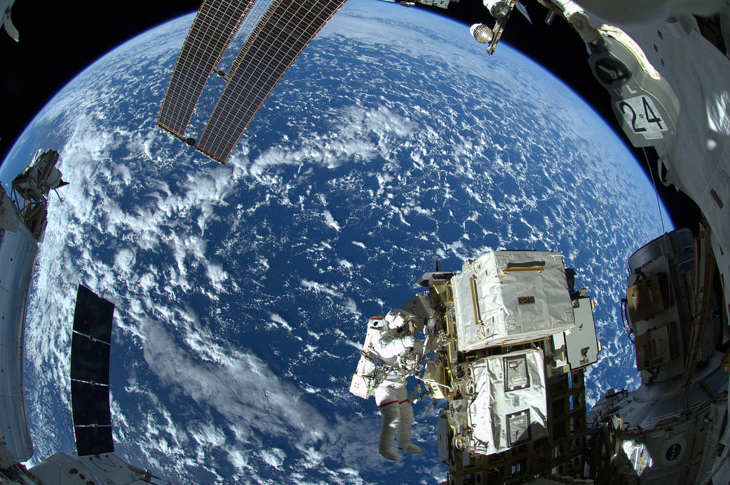 NASA astronaut Reid Wiseman on a spacewalk outside the International Space Station, with Earth visible in the background.