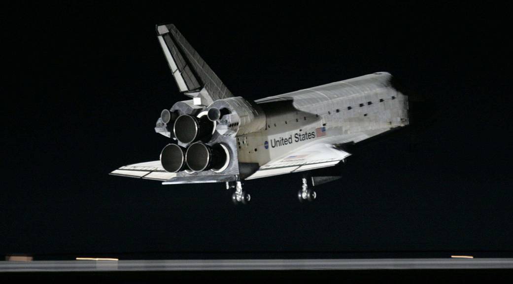 Shuttle Atlantis just about to touch down on runway at night