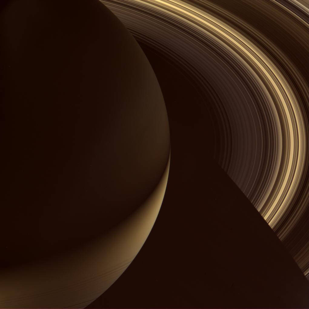 Closeup of Saturn from above showing half the planet in sepia tones and surrounding close rings