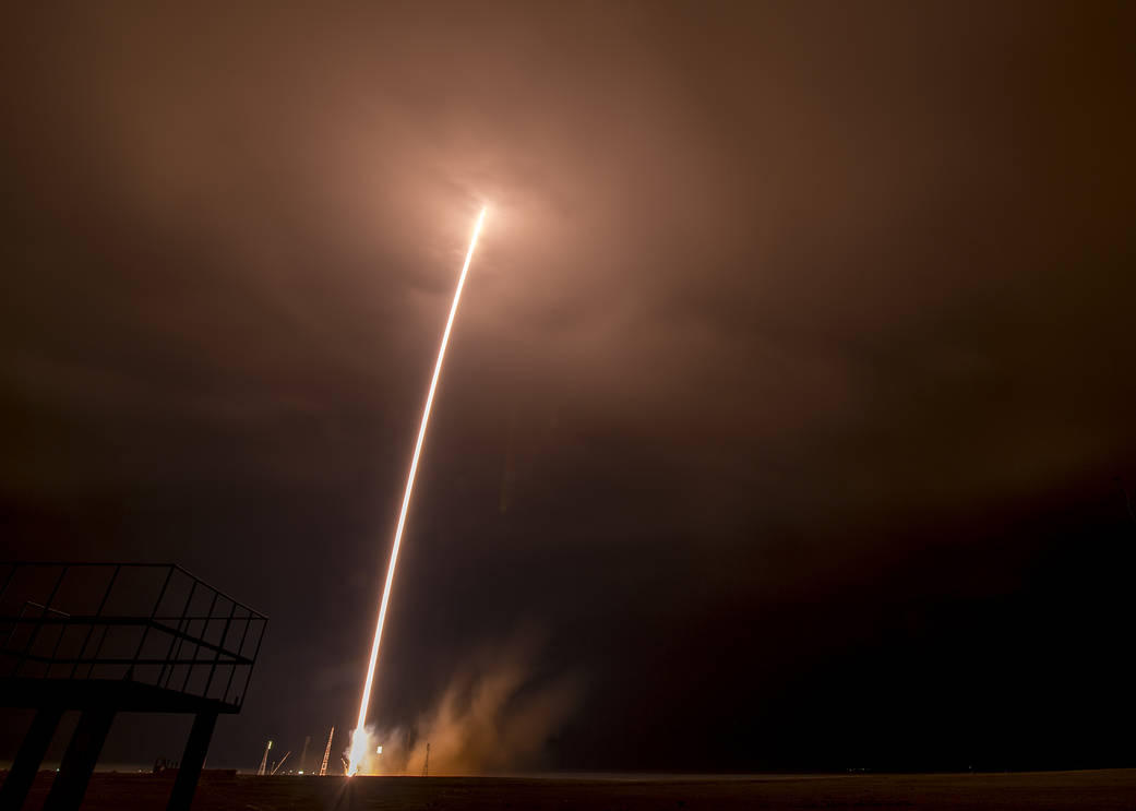 Long exposure of Soyuz rocket launch showing arc of light from launch pad to sky