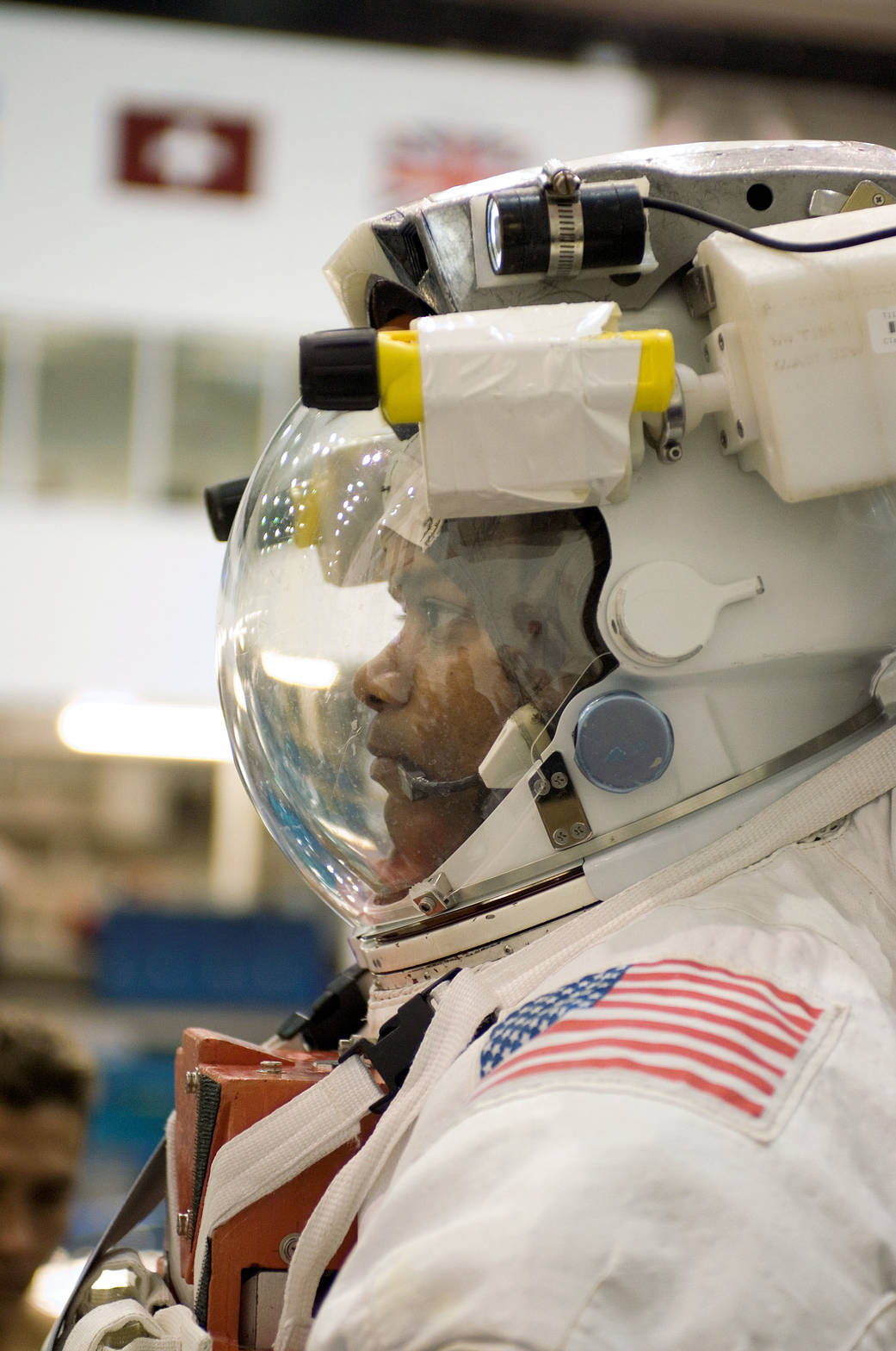 Closeup image from the side of astronaut in spacesuit with helmet