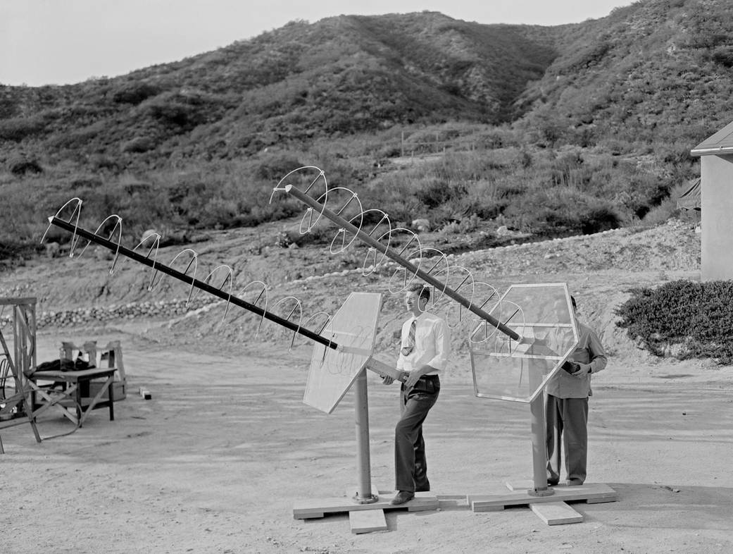 Twp scientists in field at NASA JPL directing large antenna receivers