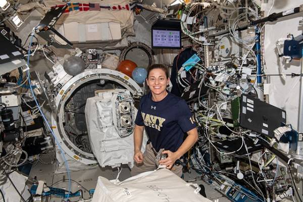 image of an astronaut preparing cubesats for deployment from the space station