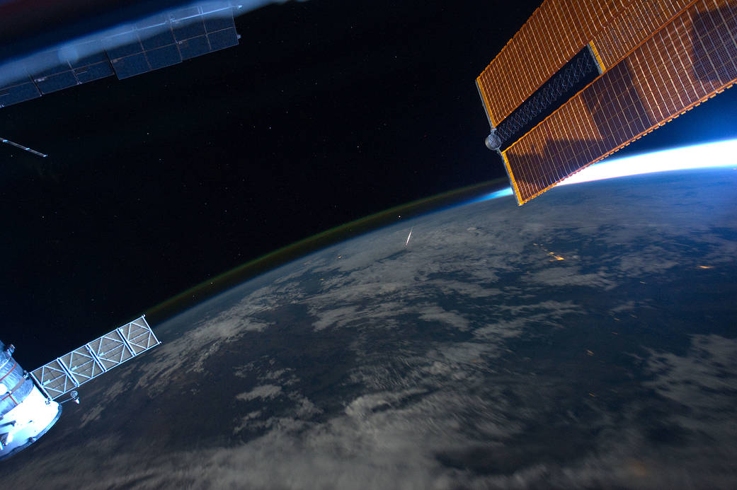 Earth from International Space Station with meteor visible and solar array at right