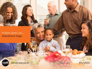 Aviation gives you...Grandma's hugs. Image of a grandma with her grandson on her lap as she's giving him a hug at the Thanksgiving table with friends and family around them.