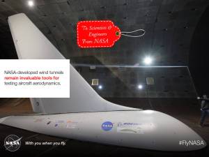 NASA-developed wind tunnels remain invaluable tools for testing aircraft aerodynamics. Image showing a large full-scale airplane tail in the wind tunnwl with a red gift tag that says, To: Scientist and Engineers. From: NASA.