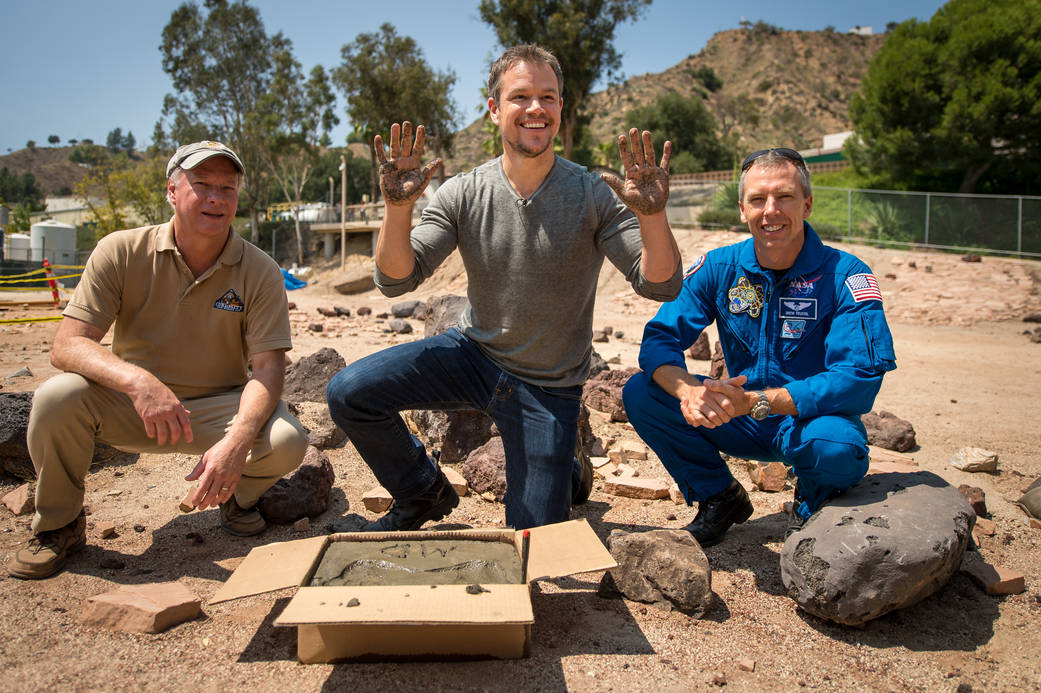 Actor Matt Damon smiles after having made his hand prints in cement at the JPL Mars Yard