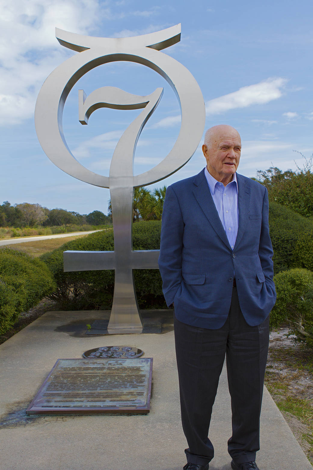 John Glenn next to silver memorial to Mercury 7 astronauts