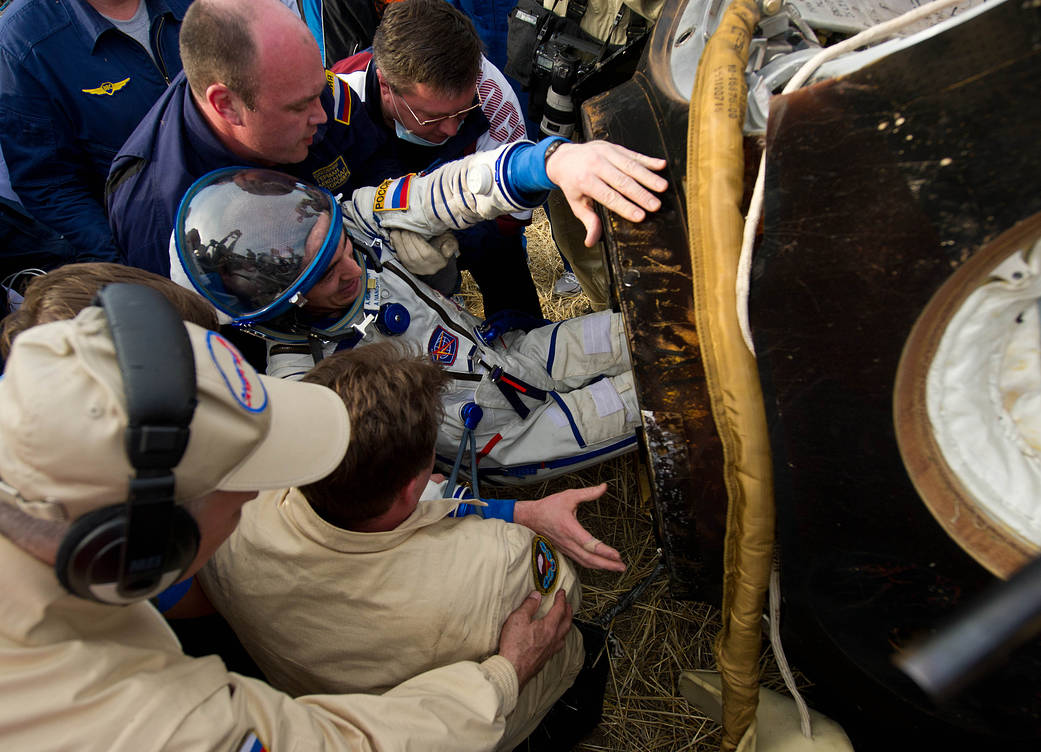 Flight Engineer Anatoly Ivanishin is extracted from the Soyuz spacecraft shortly after landing