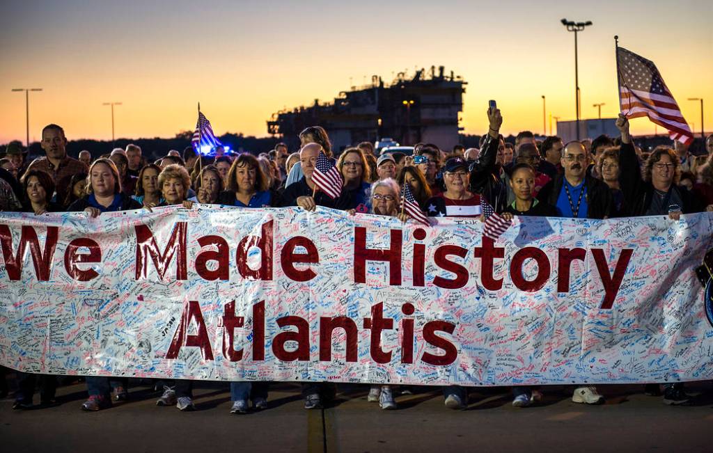 Workers carry a banner full of signatures while following behind space shuttle Atlantis as it begins its trek to its new home at the Kennedy Space Center Visitor Complex, early Friday, Nov. 2, 2012, in Cape Canaveral, Fla. 
