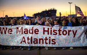 Workers carry a banner full of signatures while following behind space shuttle Atlantis as it begins its trek to its new home at the Kennedy Space Center Visitor Complex, early Friday, Nov. 2, 2012, in Cape Canaveral, Fla.