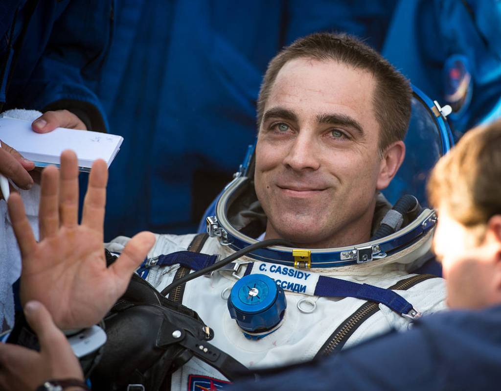 NASA astronaut Chris Cassidy waves to support personnel shortly after landing