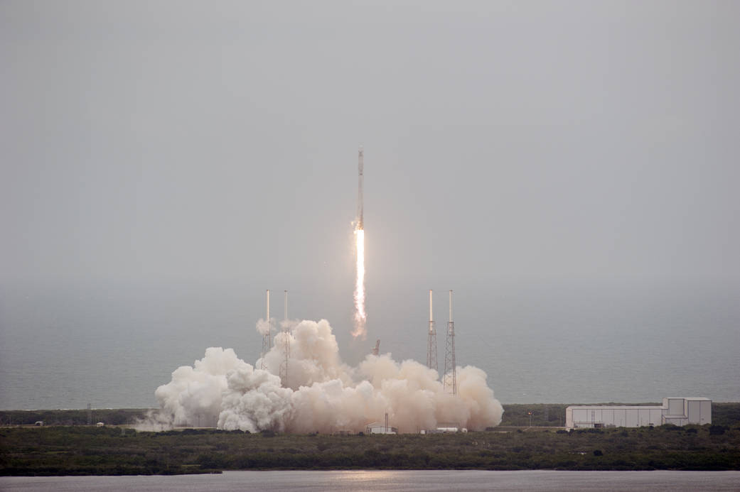 The SpaceX Falcon 9 rocket rises above the lightning masts on Space Launch Complex 40 at Cape Canaveral Air Force Station, carry