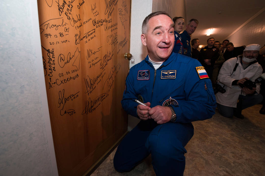 Soyuz Commander Alexander Skvortsov Signs Door at Cosmonaut Hotel