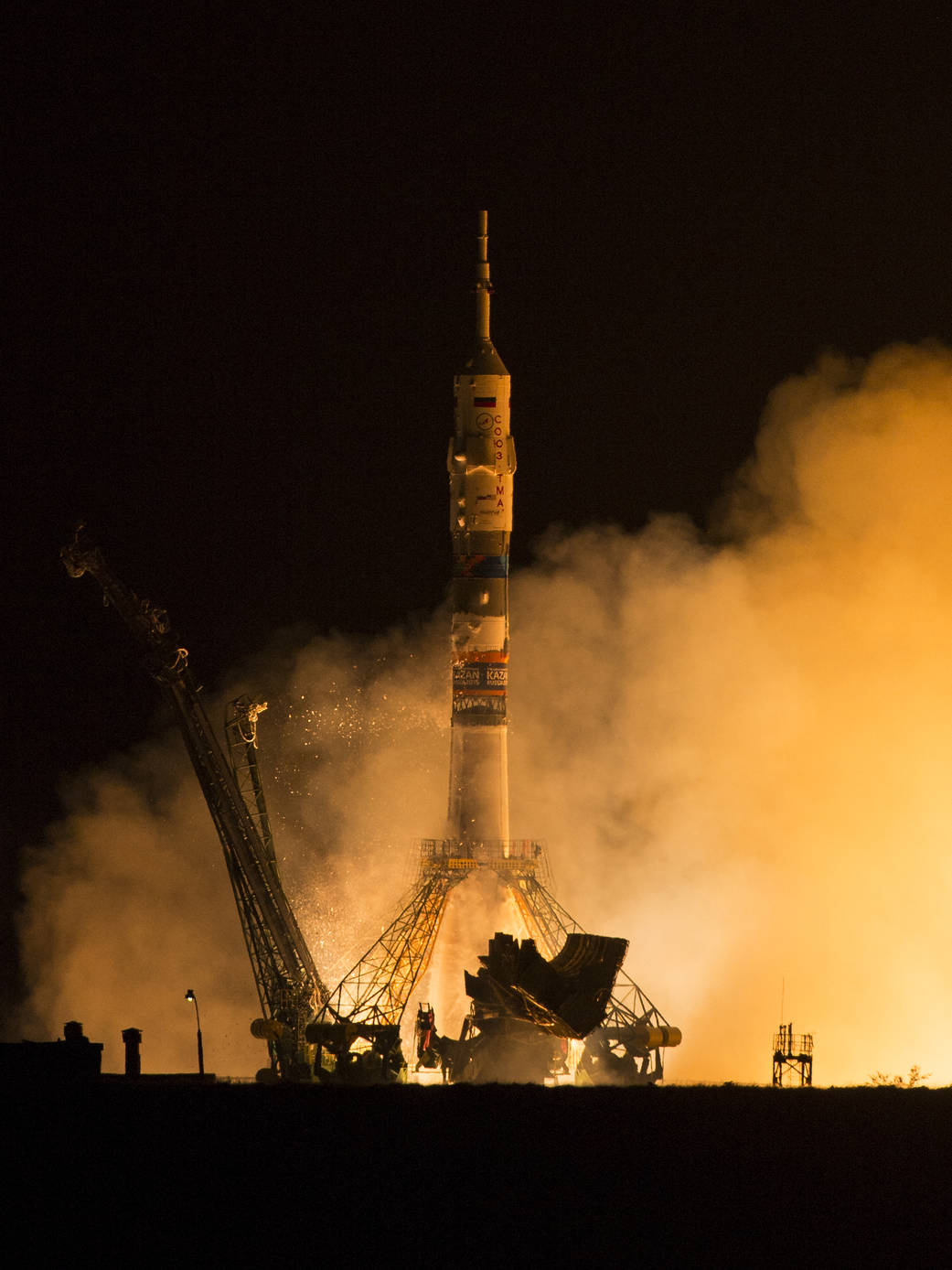 Soyuz rocket begins liftoff from launchpad at night