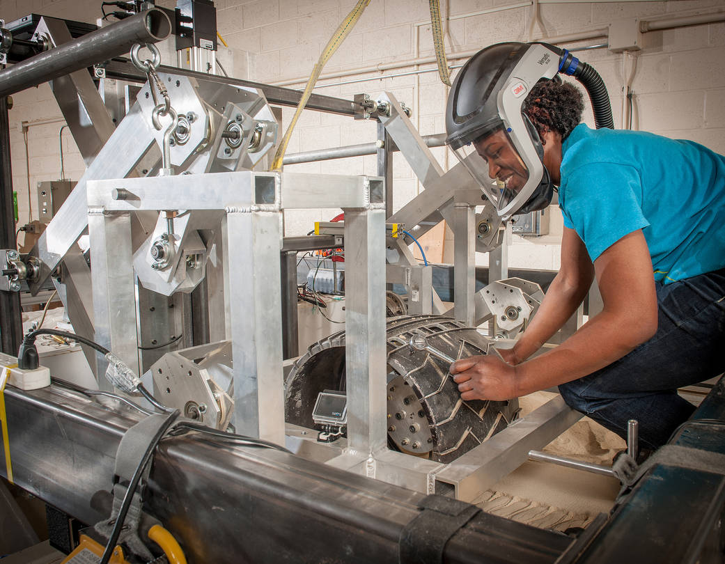 NASA Glenn technician Ariana Miller checks the wheel mount and drive hardware assembly on a Curiosity wheel 