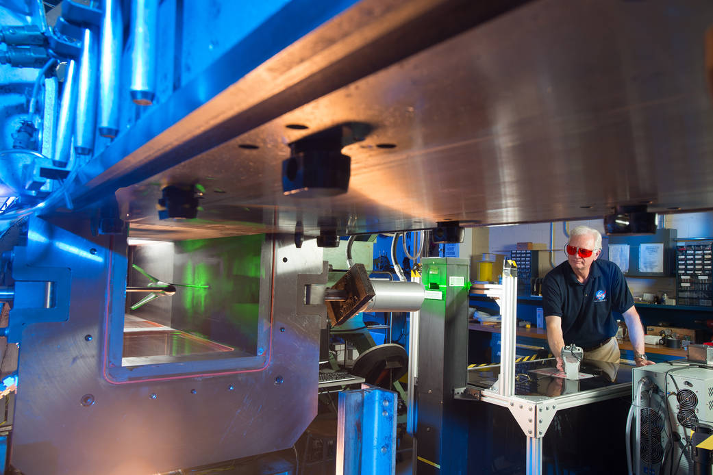 NASA Glenn Researcher Randy Locke sets up equipment for a laser testing technique in the 1 x 1 wind tunnel