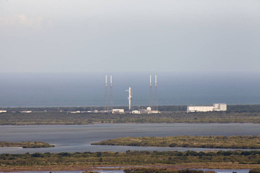A SpaceX Falcon 9 rocket stands ready to boost a Dragon capsule 