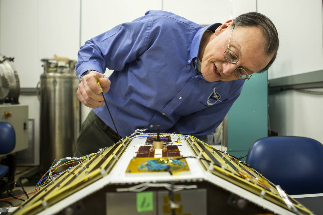 Christopher Ruf inspects CYGNSS in the lab