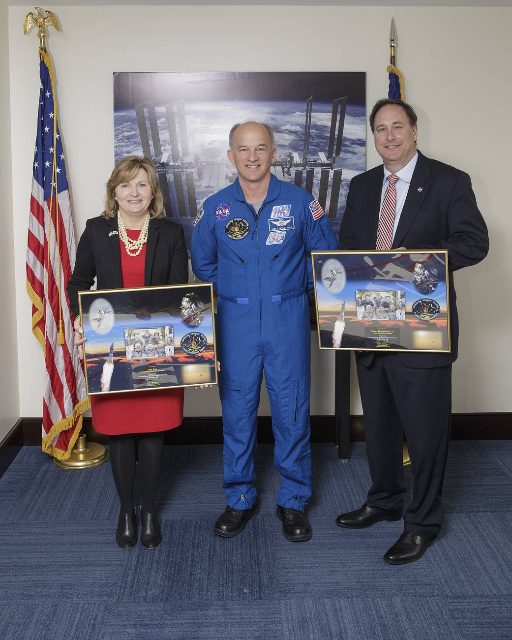 Astronaut Jeff Wiliams in blue flight suit and acting NASA Administrator and Deputy Administrator pose for photograph 