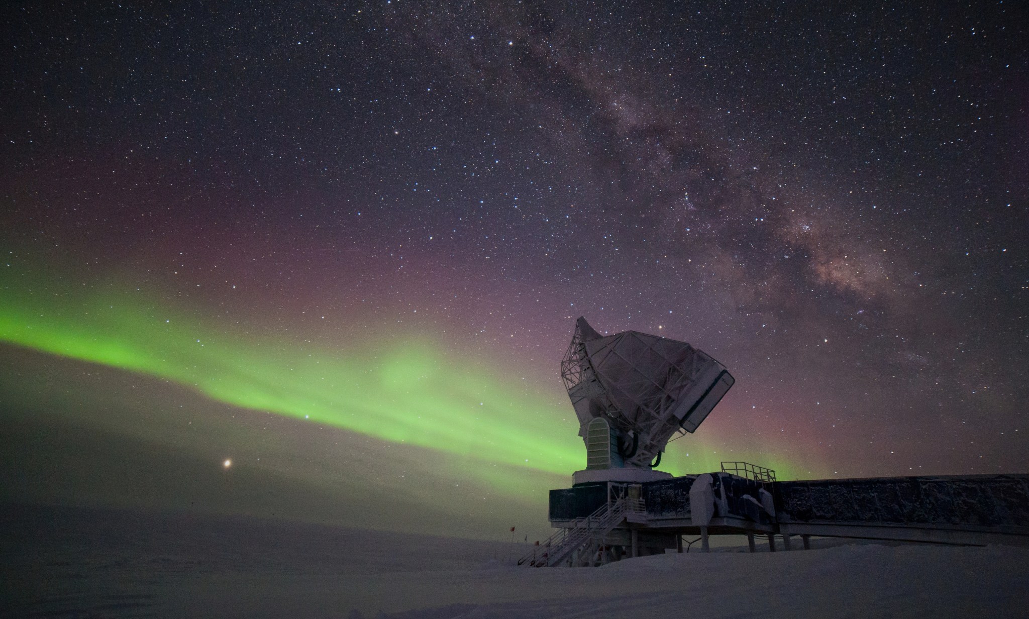 The aurora australis and the Milky Way fill the long winter night sky over the South Pole Telescope