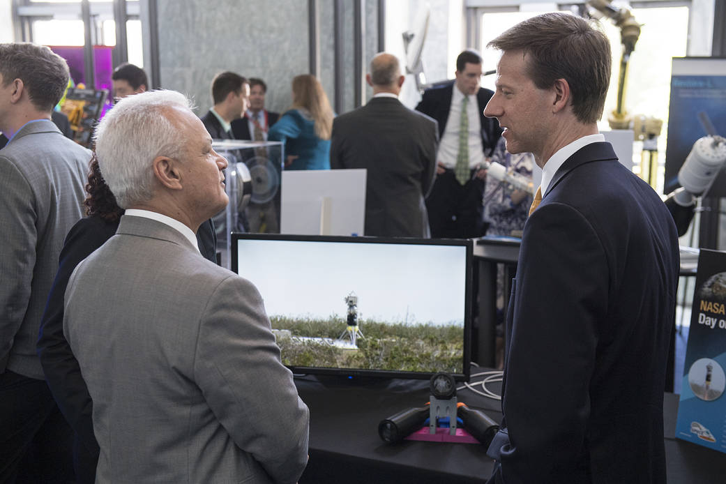 Two men talking and looking at a screen