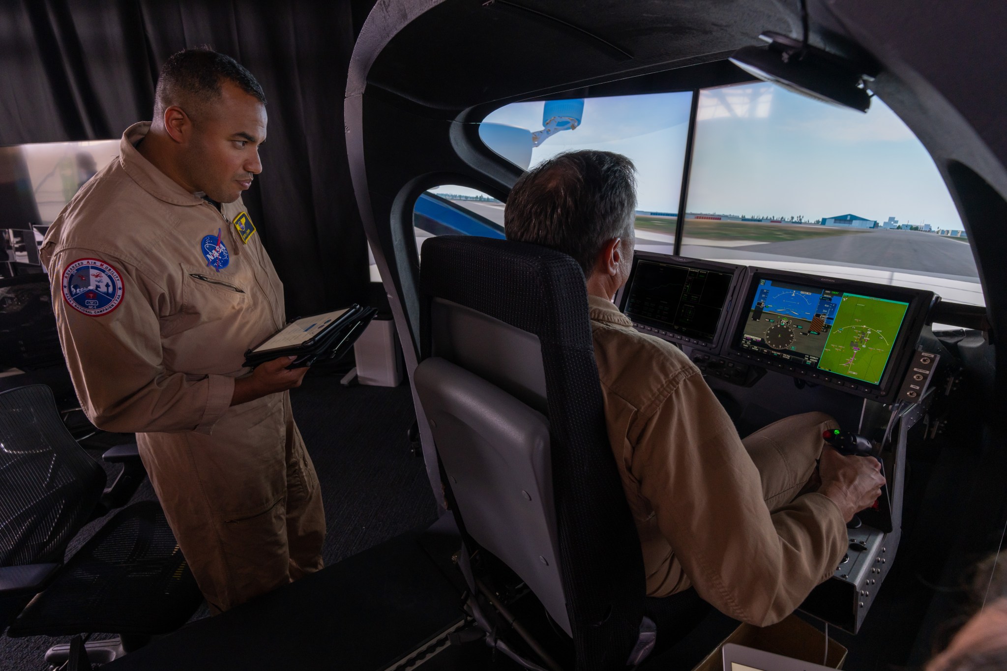 NASA research pilots at the simulator's controls.