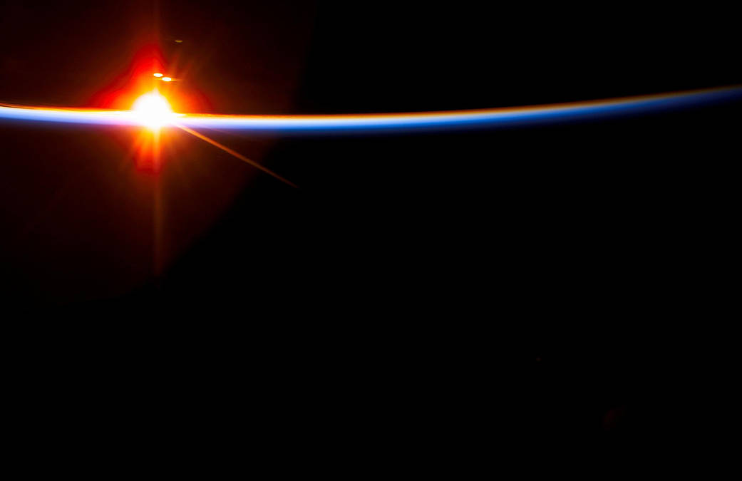 The bright sun dissects the airglow above Earth's horizon in this view photographed with a digital still camera from the Space Shuttle Columbia during the STS-107 mission.