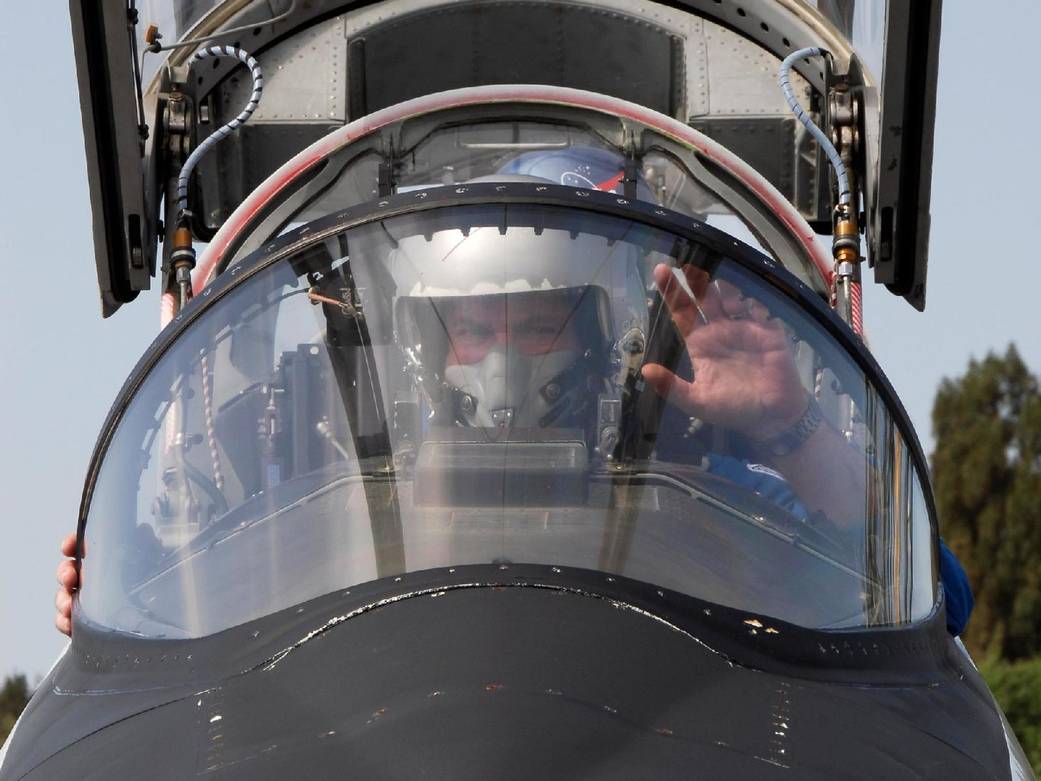 Pilot in cockpit of aircraft, close up from front