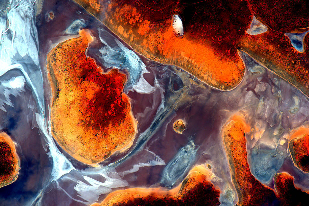 Bright shapes in orange and red on a brown landscape in Australia, photographed from the International Space Station