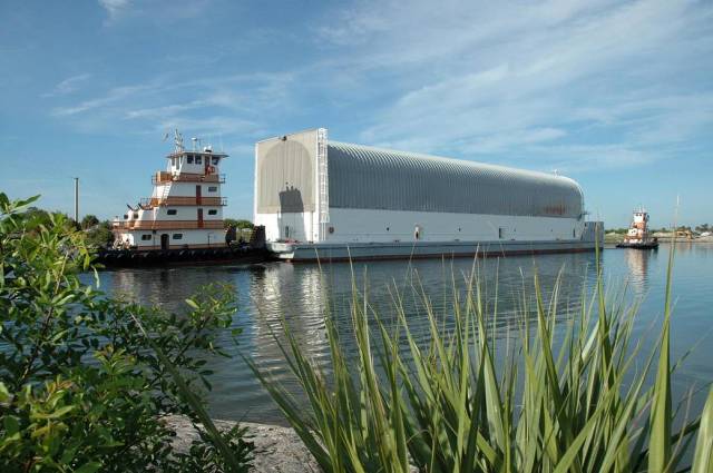 With an external tank as its cargo, tugboats tow the Pegasus barge on the Banana River near the Kennedy Space Center in Florida. 